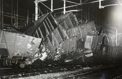 807711 Afbeelding van de over elkaar heen geschoven kolenwagens na de botsing van een goederentrein met een losse ...